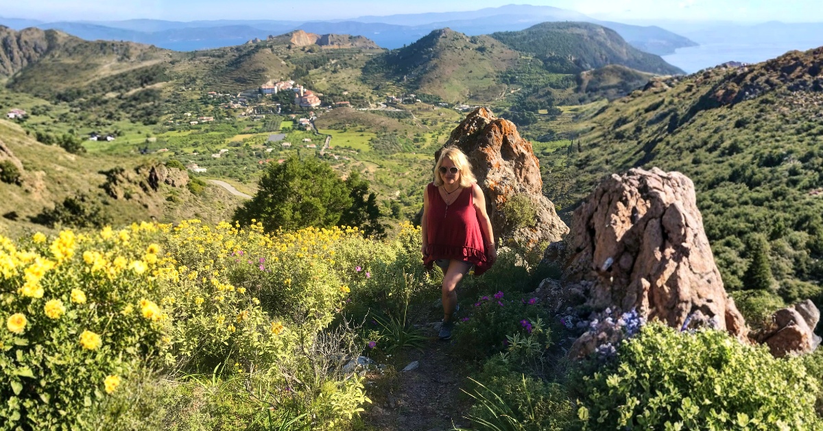 Lizzy walking in the mountains opposite Agios Nektarios Monastery on Aegina Island — a reflection on healing and clarity.